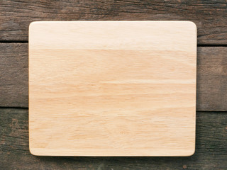 The blank wooden board on the old deep brown planks background.