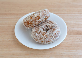 Plain coconut flake donuts on a white plate