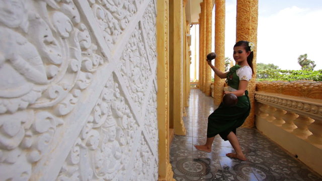 Beautiful Asian Girl performs coconut folk dance in temple