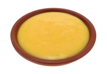 Bowl of honey mustard dressing on a white background