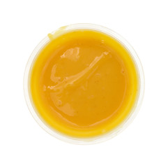 Container of honey mustard dressing on a white background