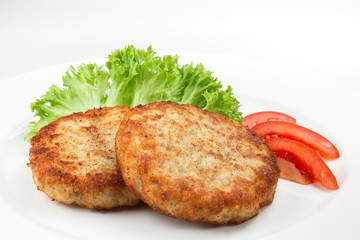 Pork cutlets with salad and slices of tomato isolated on white background 