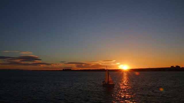 Yacht sailing against the setting sun. Sailboat of  sunset