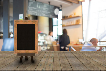 Blackboard menu with easel on wooden table with blur coffee shop