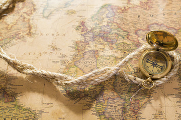 old compass and rope on vintage map