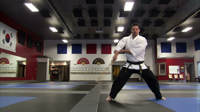 Low angle view of a martial arts instructor using a bo staff.