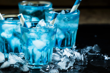 Blue cocktail with crushed ice on a dark background, selective f