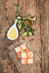 natural olive oil soap bars on wooden table decorated with olives and oil bottle