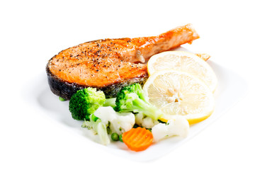 Grilled salmon with steamed vegetables on plate isolated on whit