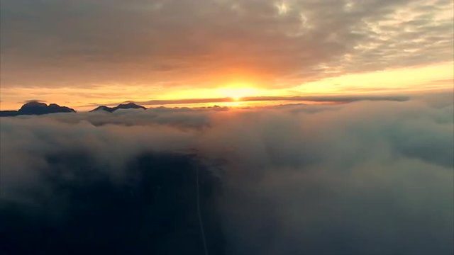 Scenic aerial view of midnight sun above the clouds on Lofoten islands in Norway. Aerial 4k Ultra HD.