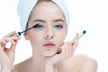 Young woman with Mascara brush / photo composition of blonde girl in towel - isolated on white background