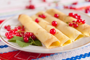 Pancakes decorated with red currant berries.