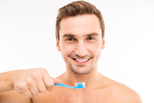 Handsome man holding a toothbrush.