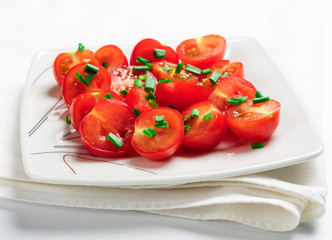 Cherry tomatoes decorated with green onions.