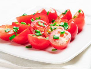 Cherry tomatoes decorated with green onions.