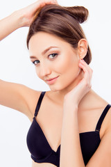 Obraz premium Close up portrait of girl in black bra making hairstyle