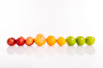 Colorful fruits standing in a row on white isolated background.