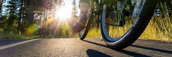 Cercles muraux Vélo Vélo sur le chemin asphalté illuminé par le soleil