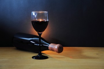 Wine glass and old bottle on a wooden table