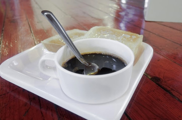 Cup of coffee / Cup of coffee and slice of bread with milk on the table.