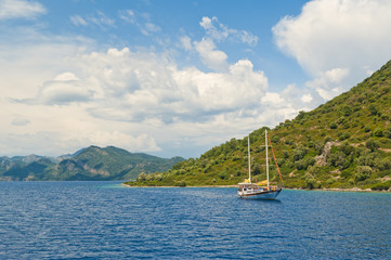 Fototapeta na wymiar tourist boat in sea at green mountainous island
