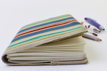 notebook with bright cover and pen isolated on white background