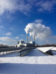 Solaranlage vor Heizkraftwerk mit Schnee bedeckt