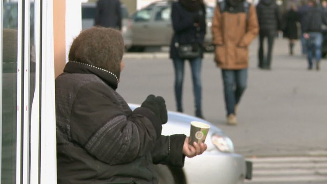 An elderly woman begging on the street.Poverty.