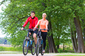 Obraz premium Woman and man on mountain bike in the woods