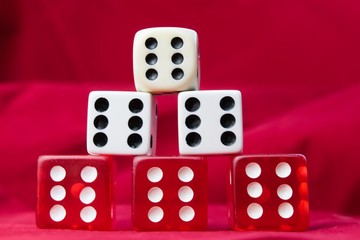 A stack of die showing sixes against red felt