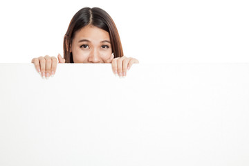 Beautiful young Asian woman behind a blank sign