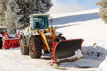 large tractor with snow plow  during a winter