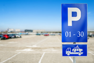 Parking lot with number of authorized parking sign with tow truck