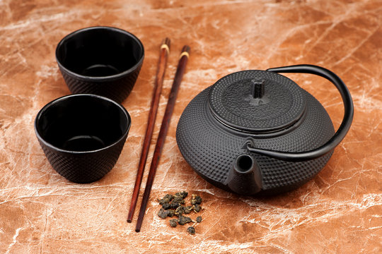 Asian Green tea in a cast-iron teapot and cups