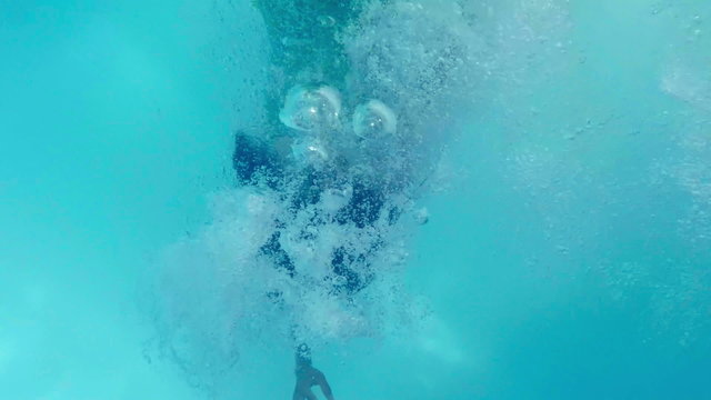Pretty woman in green dress diving in the pool