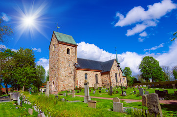 Fototapeta na wymiar Old sweden church with cemetery in small town near Stockholm - Vallentuna, vivid natural outdoor Sweden background