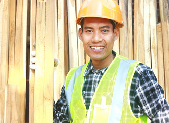 Portrait of a smiling carpenter holding wood