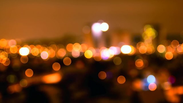 Abstract colorful defocused city lights with bokeh effects at night. Warm tone orange light background. Zoom in camera style.
