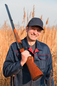 Man posing with a gun in autumn day