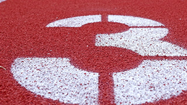 Slow dolly of a number 3 on a running track