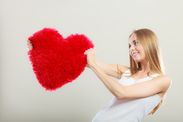 woman holding heart shaped pillow love symbol