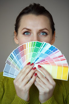 Woman with a red lips looking to a color paint palette