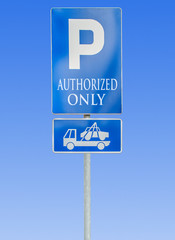 Road parking sign isolated against a blue sky with authorized only and tow truck sign
