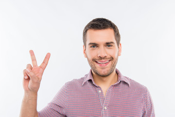 Fototapeta premium Cheerful young man gesturing with two fingers