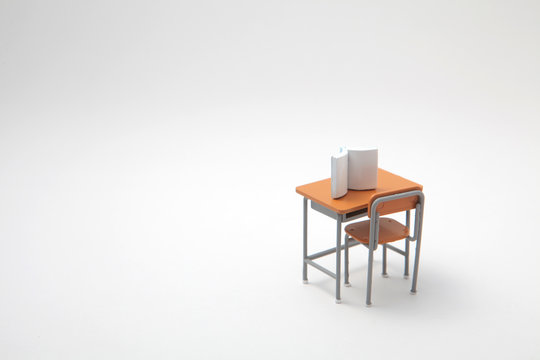 Book And Miniature Learning Desk  On White Background