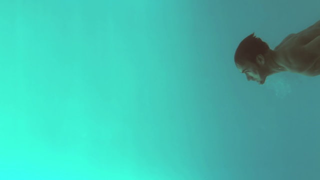 Underwater View Of Athletic Man Diving In The Swimming Pool