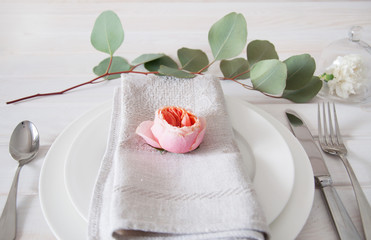 Decorated table setting with linen napkins, rose and white carna