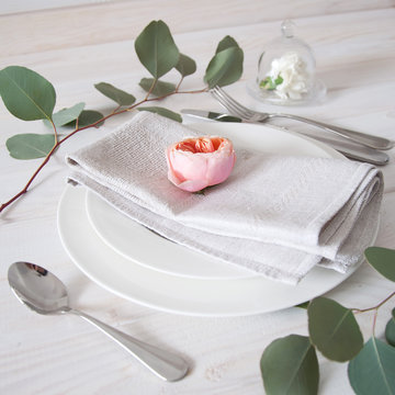 Decorated table setting with linen napkins, rose and white carna