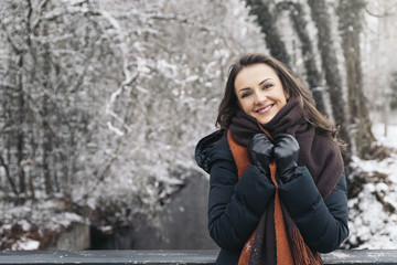 Portrait of smiling young woman in winter park.