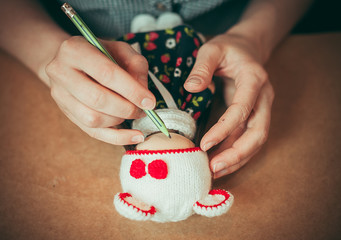 Young woman is making a doll